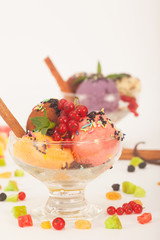 Fruit flavored ice cream with dry fruit, vanilla sticks and fresh currant, vertical