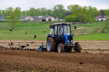 Fototapeta premium Tractor plowing the land in Russia