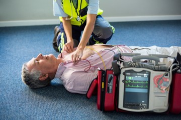 Paramedic using an external defibrillator - obrazy, fototapety, plakaty