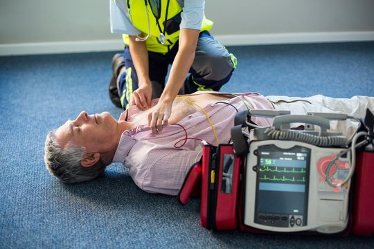 Paramedic using an external defibrillator
