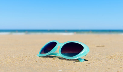 Fototapeta na wymiar sunglasses on the beach sand
