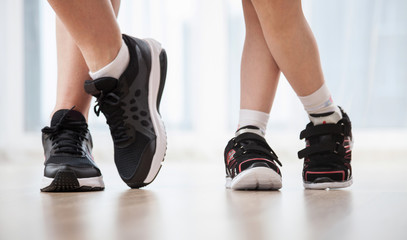 Child's and woman's legs in sports shoes