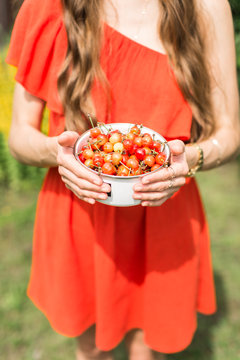 young girl holding bowl of cherries