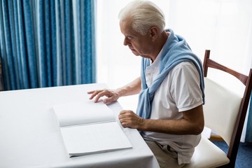 Senior man using braille to read