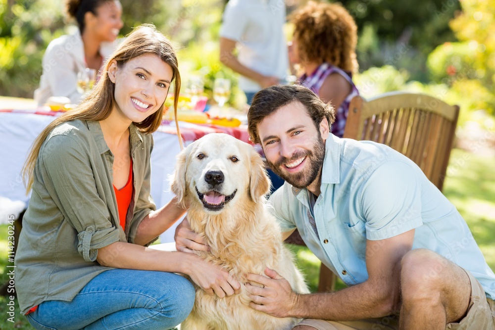 Wall mural Smiling couple with the dog