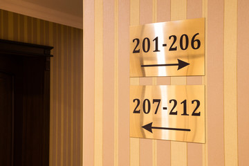 Gold colored hotel sign showing room numbers