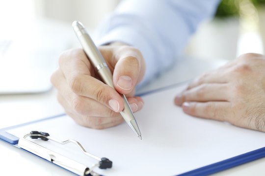 Fill the form. Close-up image of a businessman's hands initialing some paperwork.