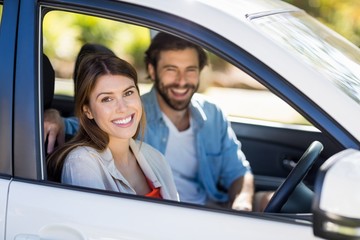 Happy couple sitting in a car