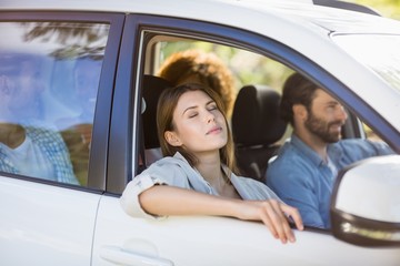 Beautiful woman relaxing in car with friends