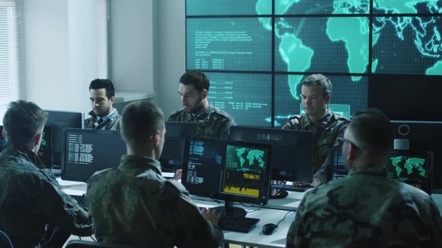Group of Military IT Professionals in Monitoring Room Filled with Displays on Military Base. Shot on RED Cinema Camera in 4K (UHD).