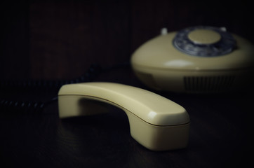 old-fashioned handset and phone on a dark wooden background. hor