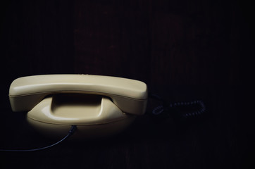back of old-fashioned phone on a dark wooden background. horizon