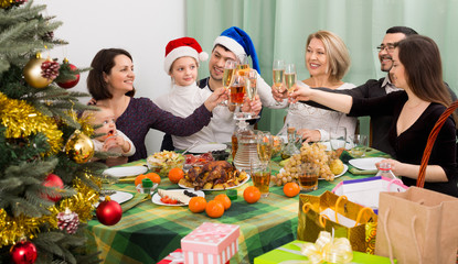 Relatives joyfully celebrate Christmas at table o
