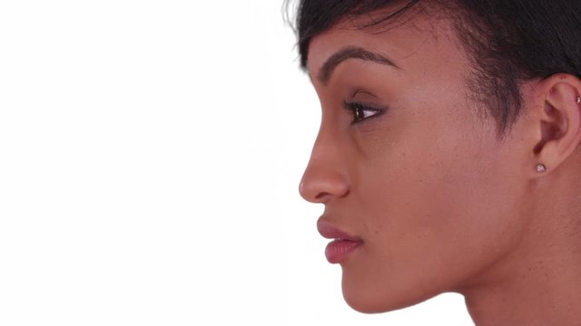 Side view of Beautiful woman with on white background turning to face camera. Black woman in her 20s with short pixie hair cut.