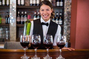 Four glasses of red wine ready to serve on bar counter