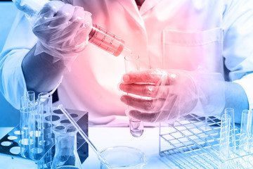 Conical flask in scientist hand with lab glassware background, L