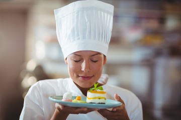 Female chef with eyes closed smelling food
