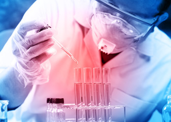 scientist  dropping chemical liquid to flask with lab glassware