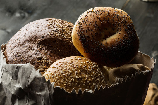tipologie di pane dentro una busta di carta su un tavolo di legno scuro