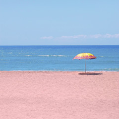 White sandy beach, sea and blue sky with umbrella 