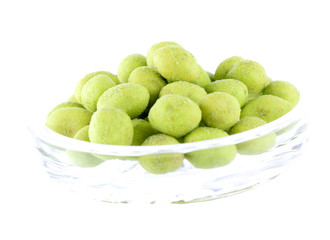 Wasabi coated peanuts in glass on white background