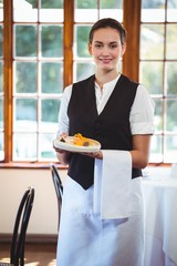 Waitress holding a plate with cakes