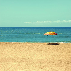 White sandy beach, sea and blue sky with umbrella 