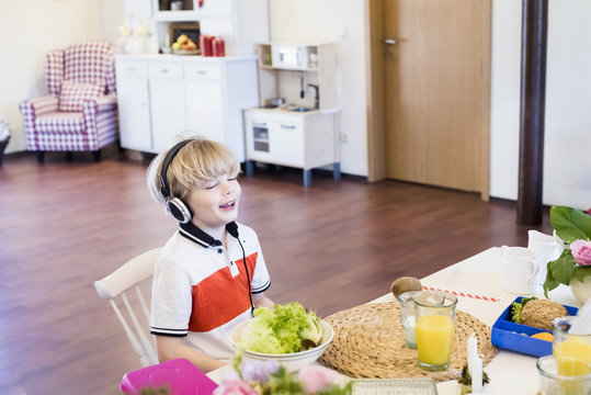 Boy wearing headphones sitting at table