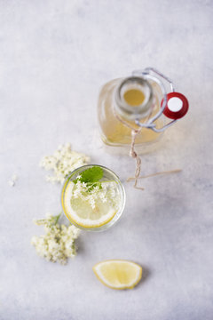 Glass of water flavoured with elderflower sirup and lemon