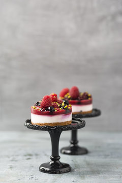 Mini fancy cakes with berries on cake stand