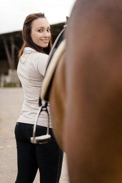 Portrait of smiling young woman with brown horse