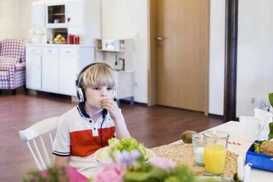 Boy wearing headphones sitting at table
