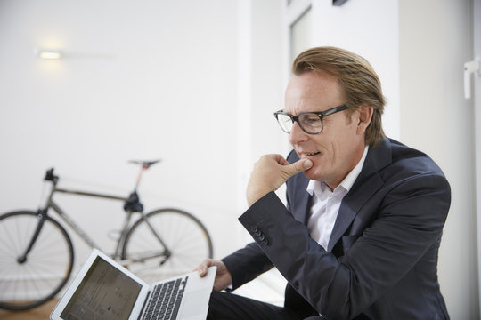 Pensive businessman with laptop