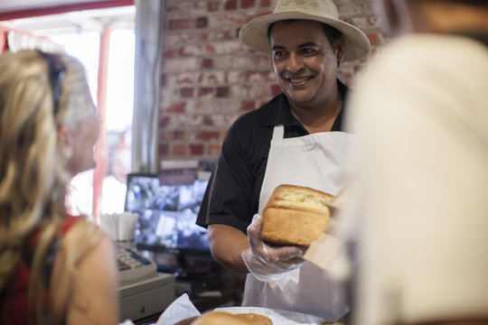 Shopkeeper in shop helping clients