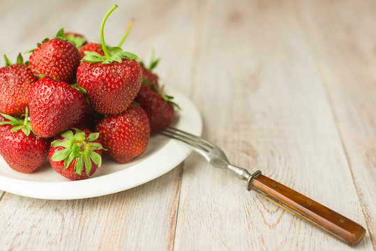 Ripe strawberry fruits on a white  plate