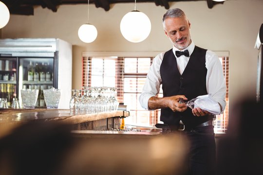 Bartender cleaning wineglass 