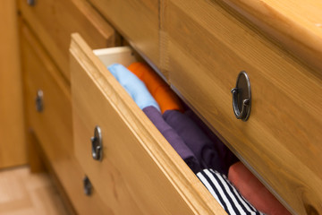Folded clothes in chest of drawers closeup
