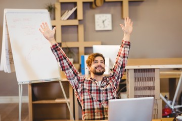 Excited graphic designer sitting with laptop