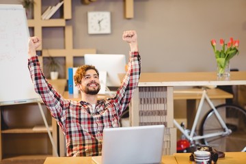 Excited graphic designer sitting with laptop