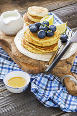 Healthy breakfast classic. Several domestic hot pancakes with fresh ripe blueberry lime zest, honey