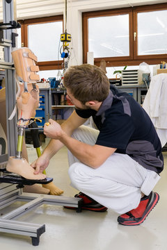 Technician working on prosthetic leg parts.