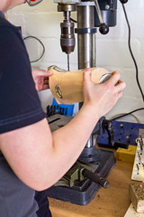 Technician drilling hole into prosthetic limb.