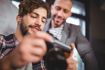 Male colleagues smiling while looking in camera 