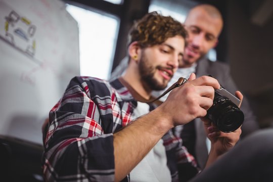 Male Coworkers Looking In Camera At Creative Office