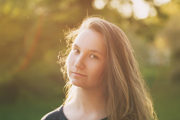 Naklejka premium pretty teen girl smiling in warm sunset
