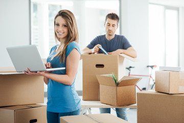 Couple using a laptop in their new house