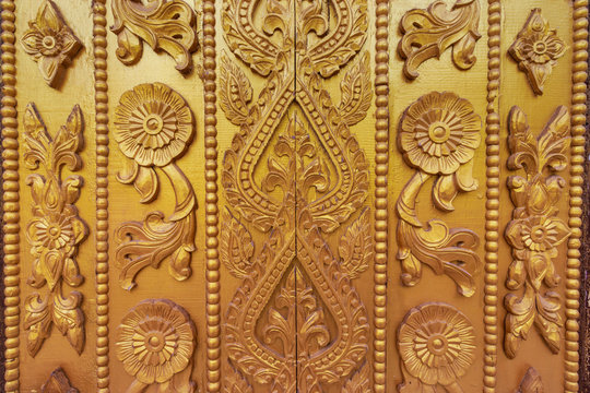 Wood carving on the wall in Myanmar. Myanmar carving on golden wall.