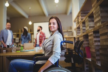 Businesswoman on wheelchair by desk 