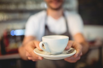 Close-up of barista serving coffee at cafeteria