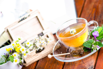 Cup of tea on a wooden backgound. Flowers and grass. Natural background. Agricultural.Garden